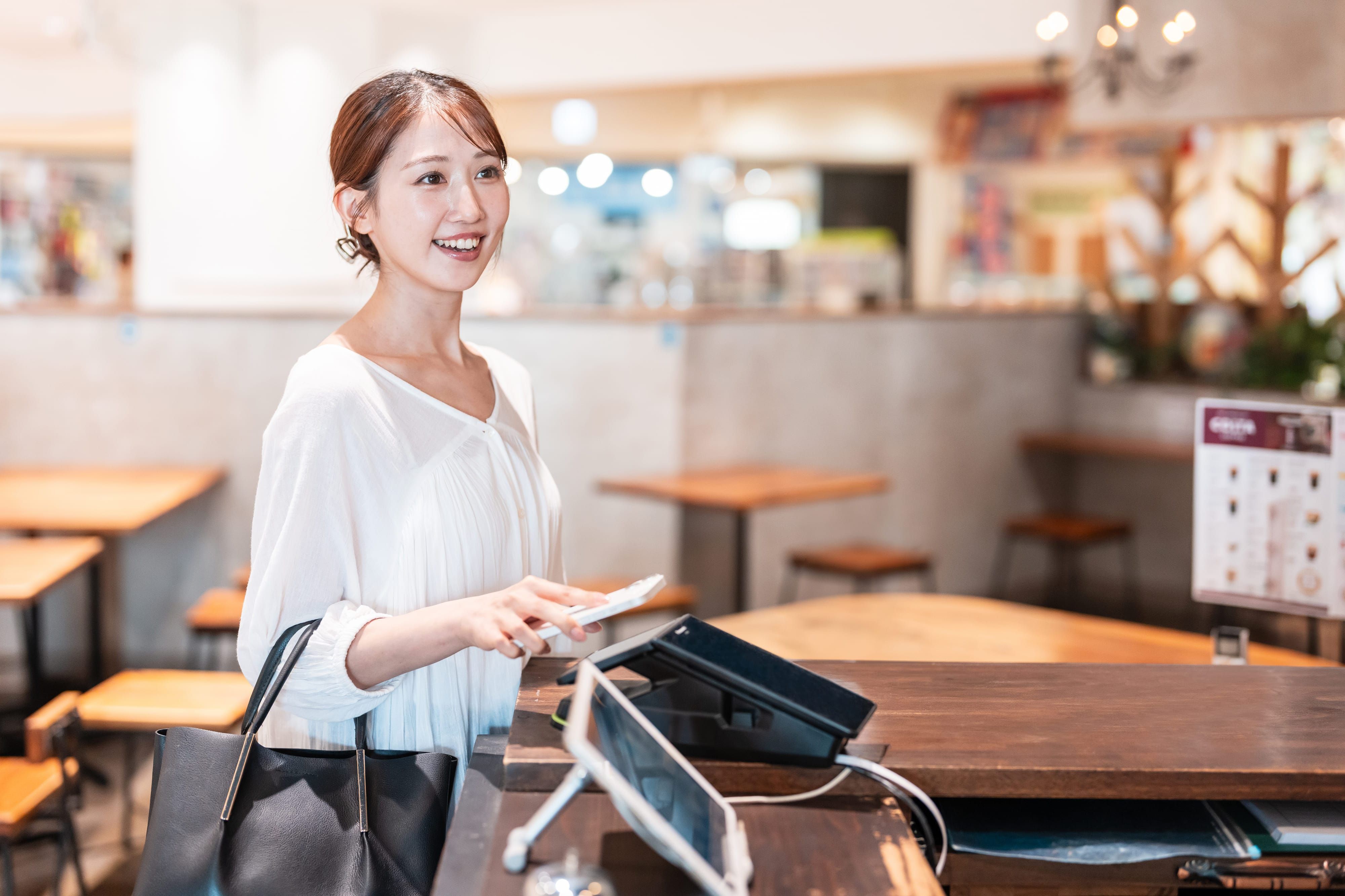 スマートウォッチで支払いをする女性